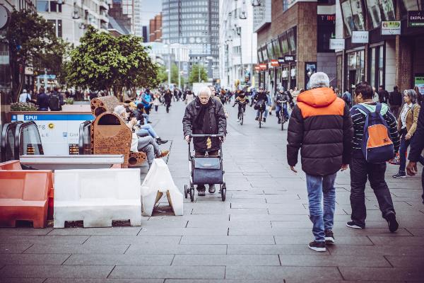 Oudere vrouw met rollator loopt alleen door Den Haag