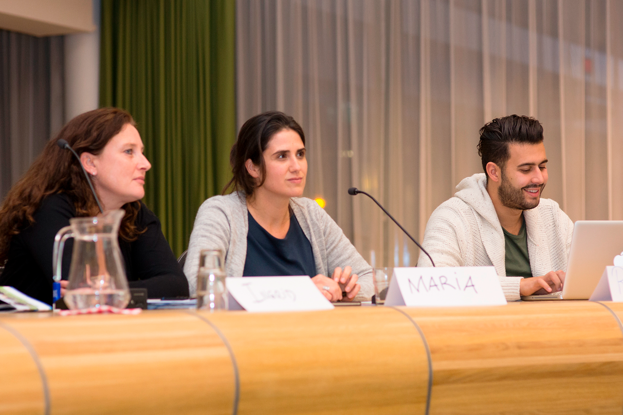 Drie studenten in collegebanken met microfoons