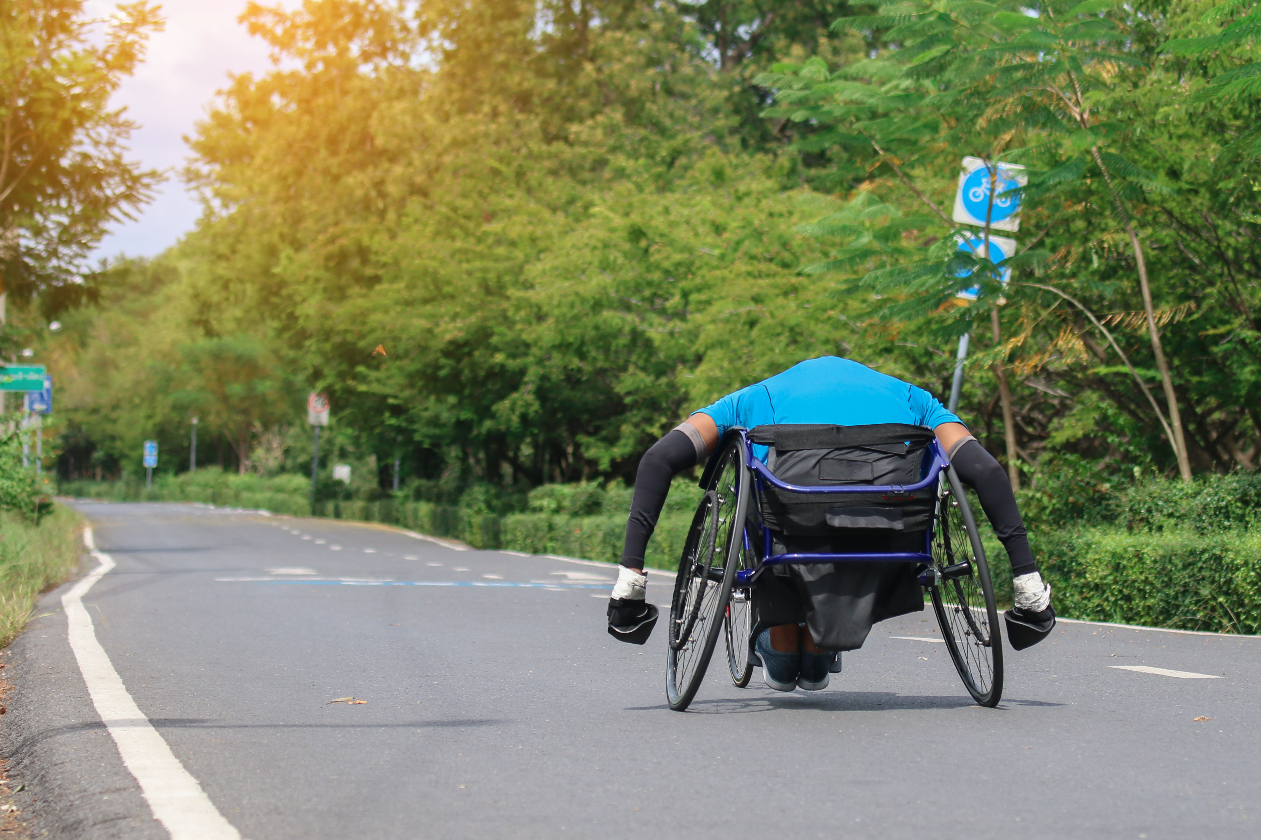 A man on a wheelchair on a fast road turning the wheel quickly