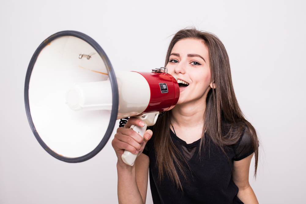 a young lady with a loudspeaker in her hand