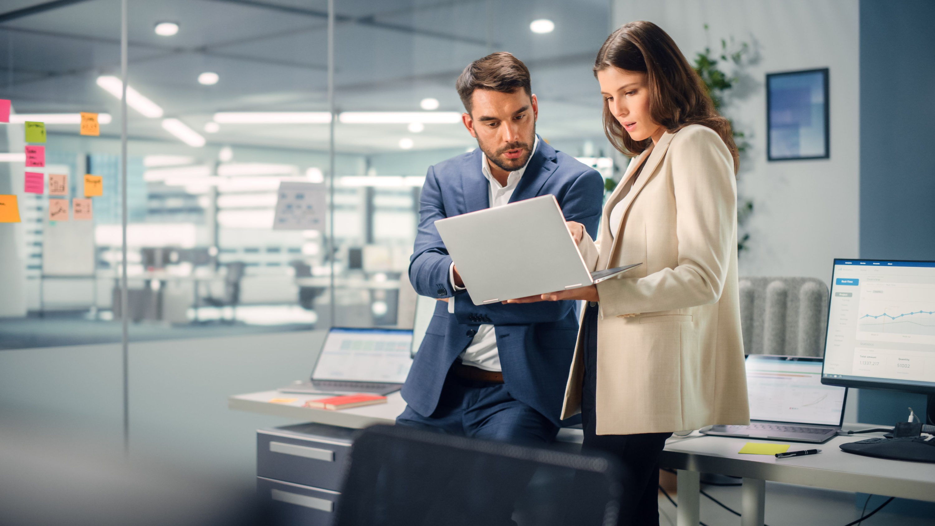 Businesss Controller, jonge manager in gesprek met ervaren collega in Office.