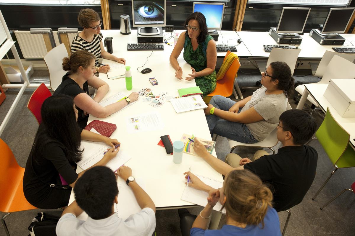 Groep studenten in overleg aan tafel