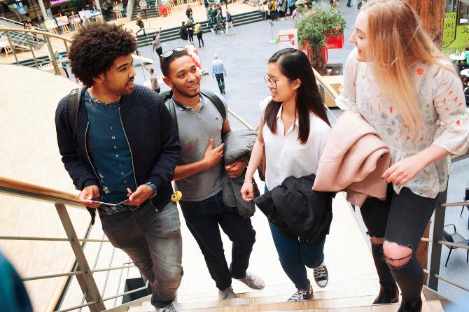 Vier studenten op de trap op de Haagse Hogeschool