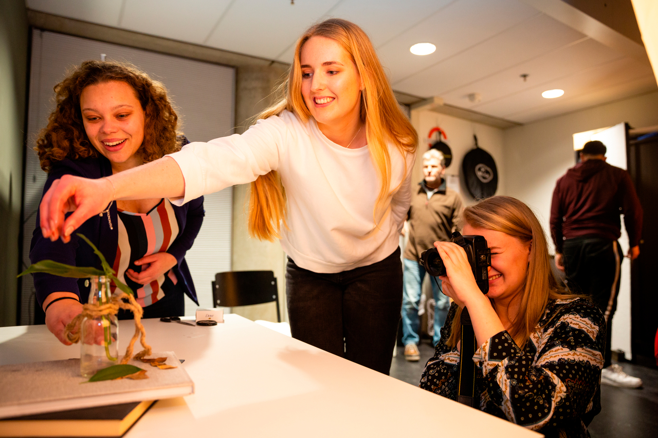 Student reikt naar object dat gefotografeerd wordt