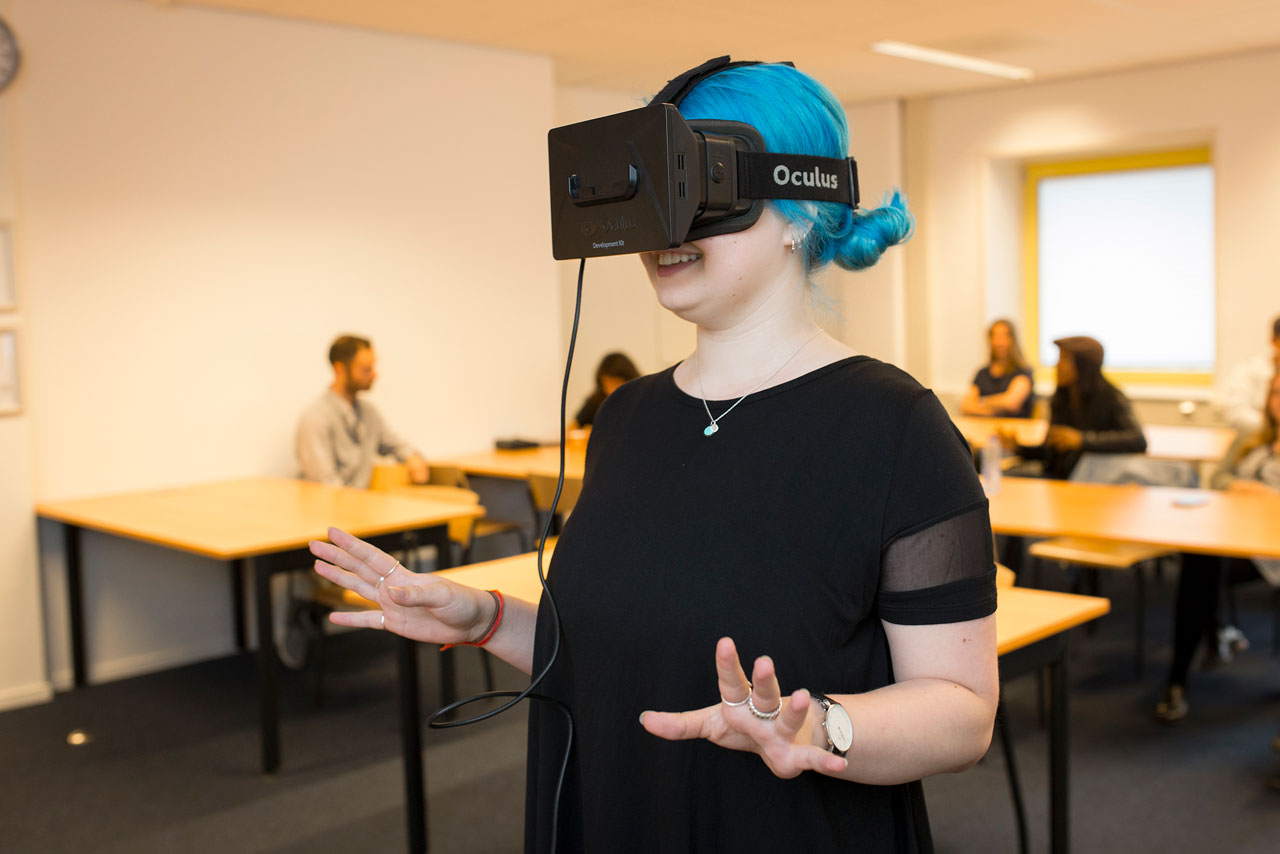 Studente met blauw haar kijkt rond met virtual reality bril