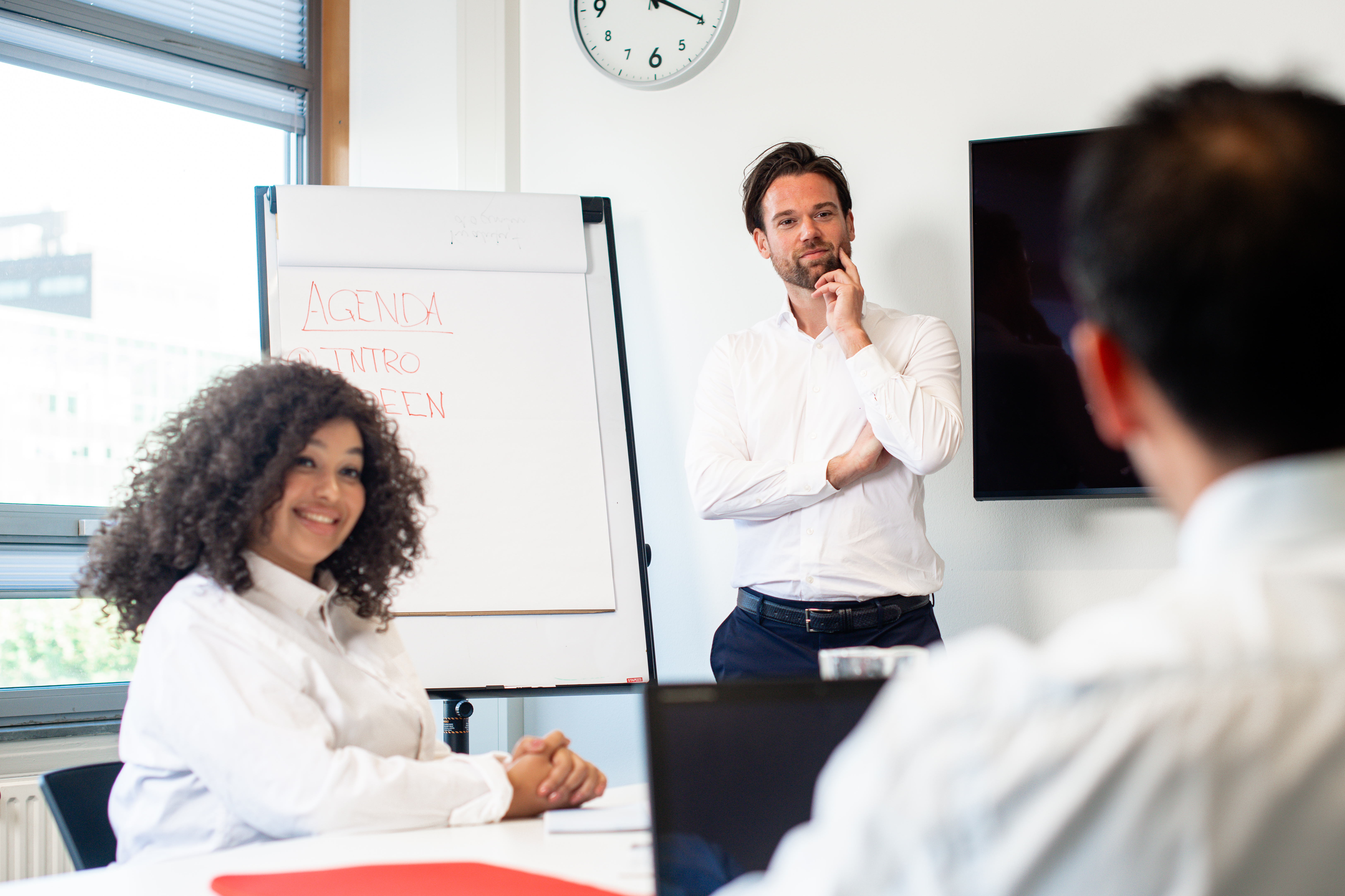 A meeting between 3 people in a classroom at The Hague University of Applied Sciences
