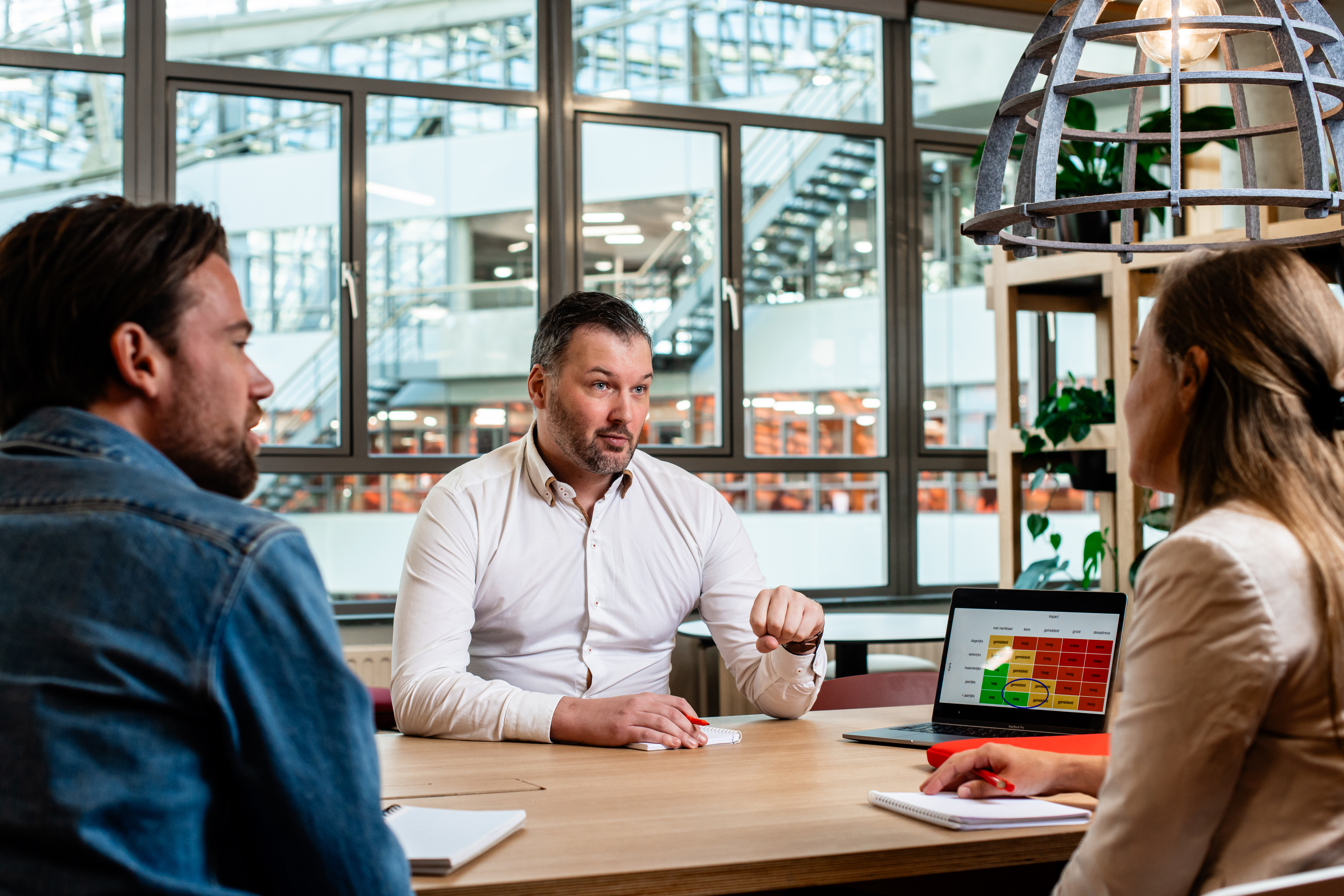 Three people having a meeting in the main building of THUAS