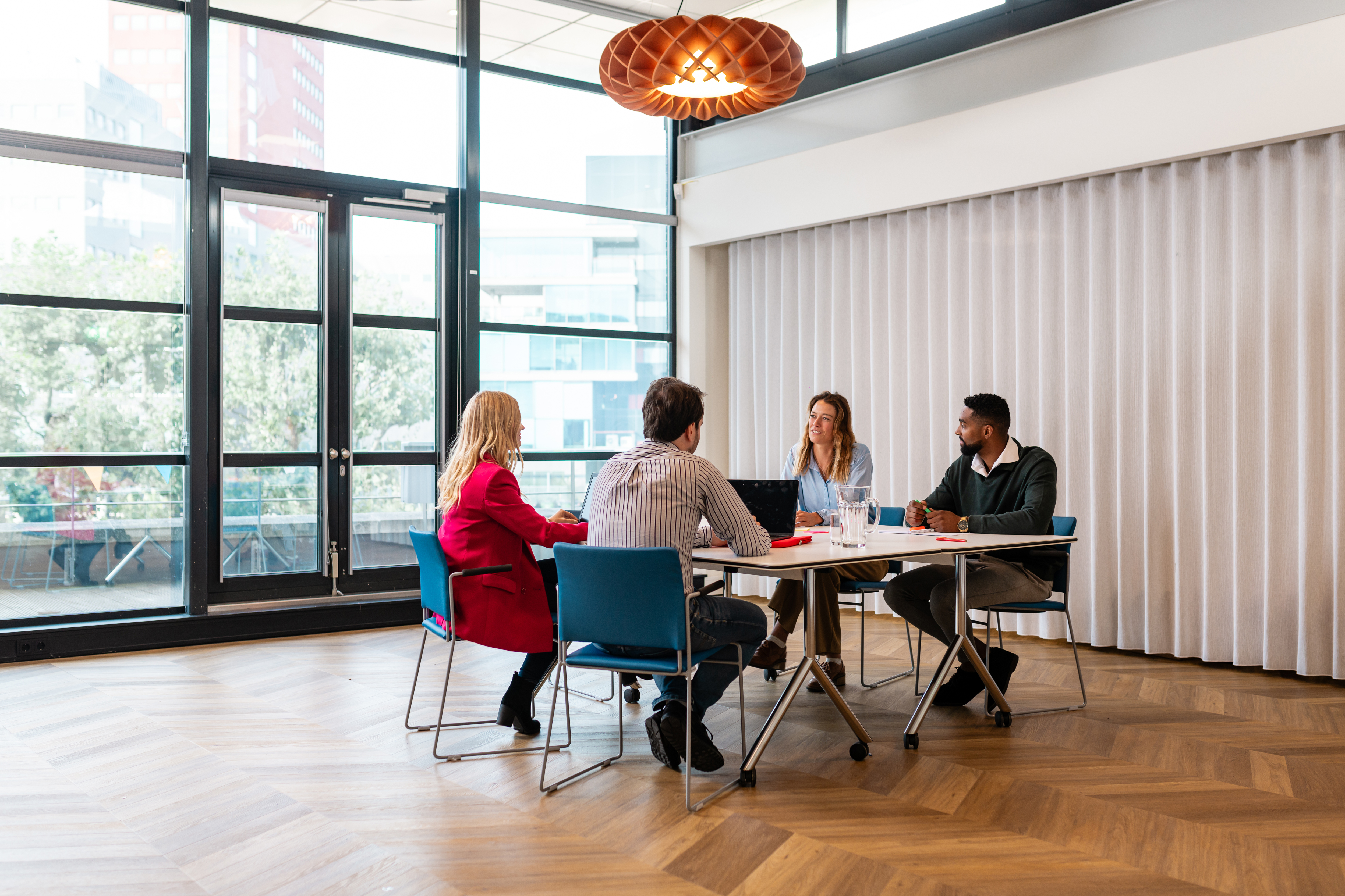 A group of 4 people having a meeting in a large room