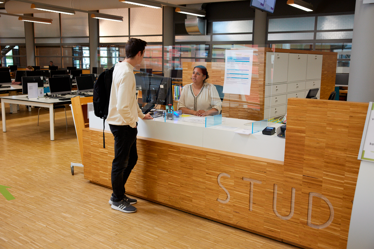 student aan bibliotheekbalie