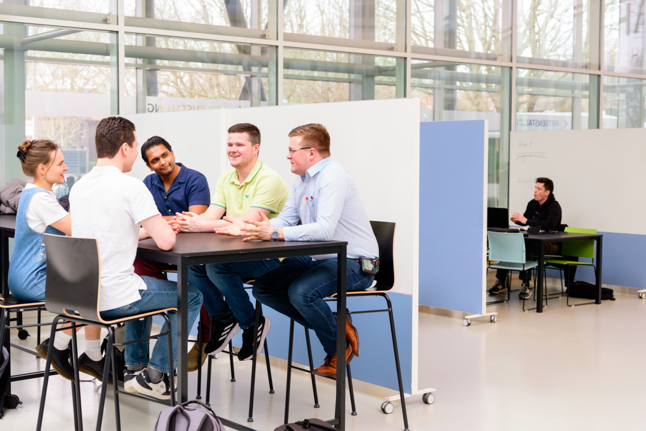 Groepje studenten zitten in een flexwerkplek