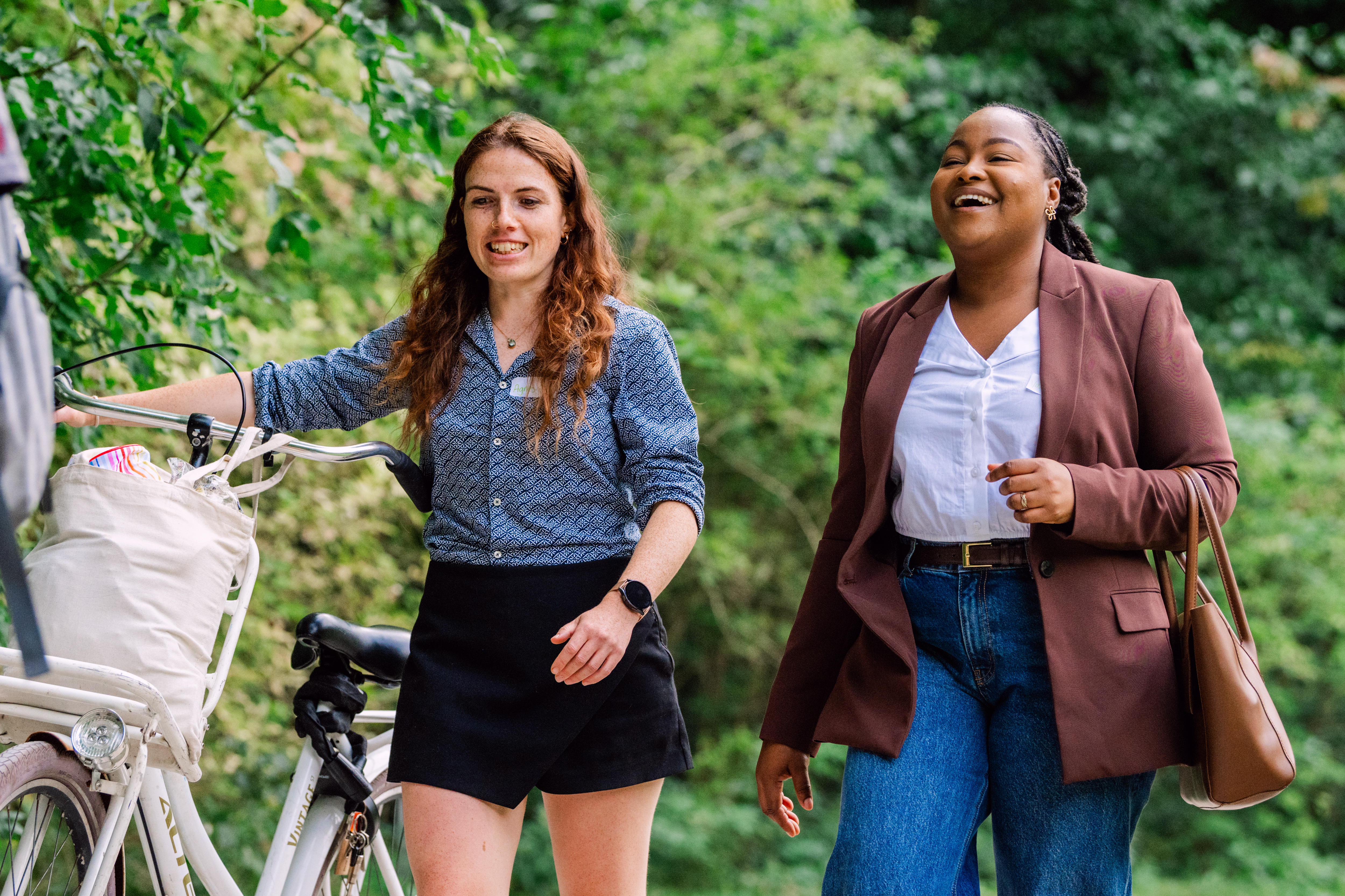 Twee studenten lopen lachend in het bos