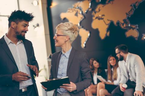 Master International Comunication Management, multi-etnische medewerkers praten voor de wereldkaart op kantoor