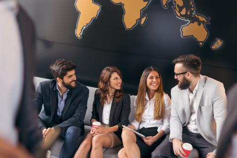 Master International Comunication Management, multi-etnische medewerkers praten voor de wereldkaart op kantoor